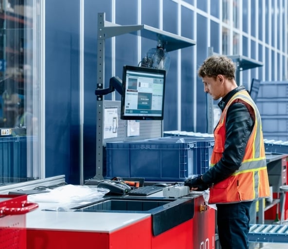 Warehouse operator picking items out of AutoStore workstation